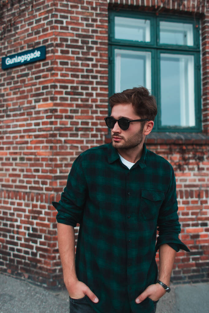 Mladý muž v brýlích s rukama v kapse stojící na městské ulici, Kodaň, Dánsko  - Fotografie, Obrázek