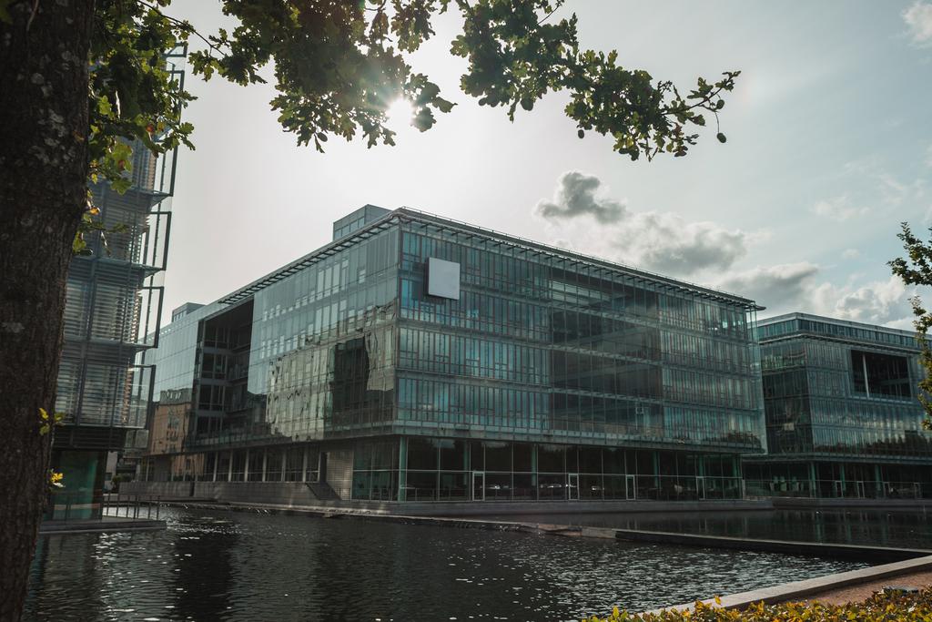 Foco seletivo da fachada de vidro do edifício perto do canal com céu nublado no fundo, Copenhague, Dinamarca
  - Foto, Imagem