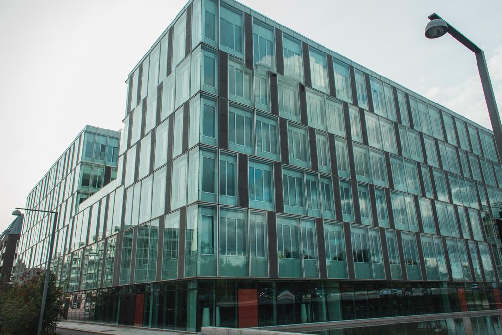 Низький кут Вигляд скляного фасаду будівлі біля ліхтарів на міській вулиці, Копенгаген, Данія.  - Фото, зображення
