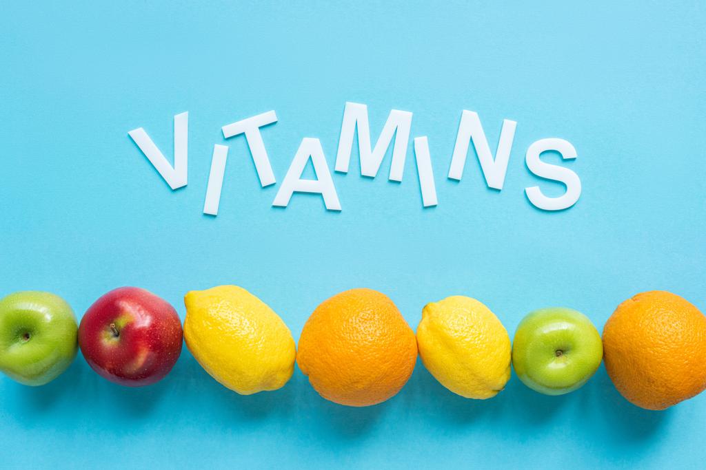 верхний вид спелых фруктов и витаминов слова на голубом фоне
 - Фото, изображение