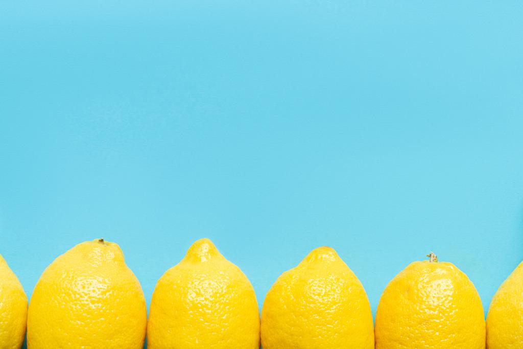 vista superior de limón amarillo maduro sobre fondo azul con espacio para copiar
 - Foto, imagen