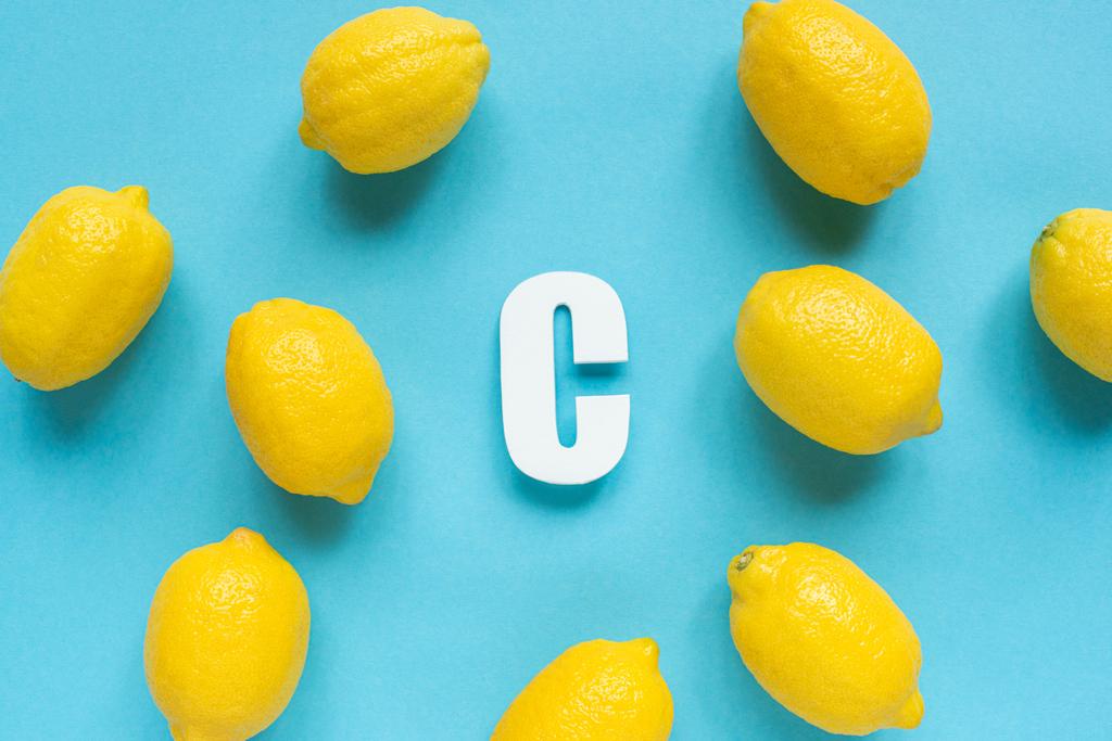 vue du dessus des citrons jaunes mûrs et lettre C sur fond bleu
 - Photo, image