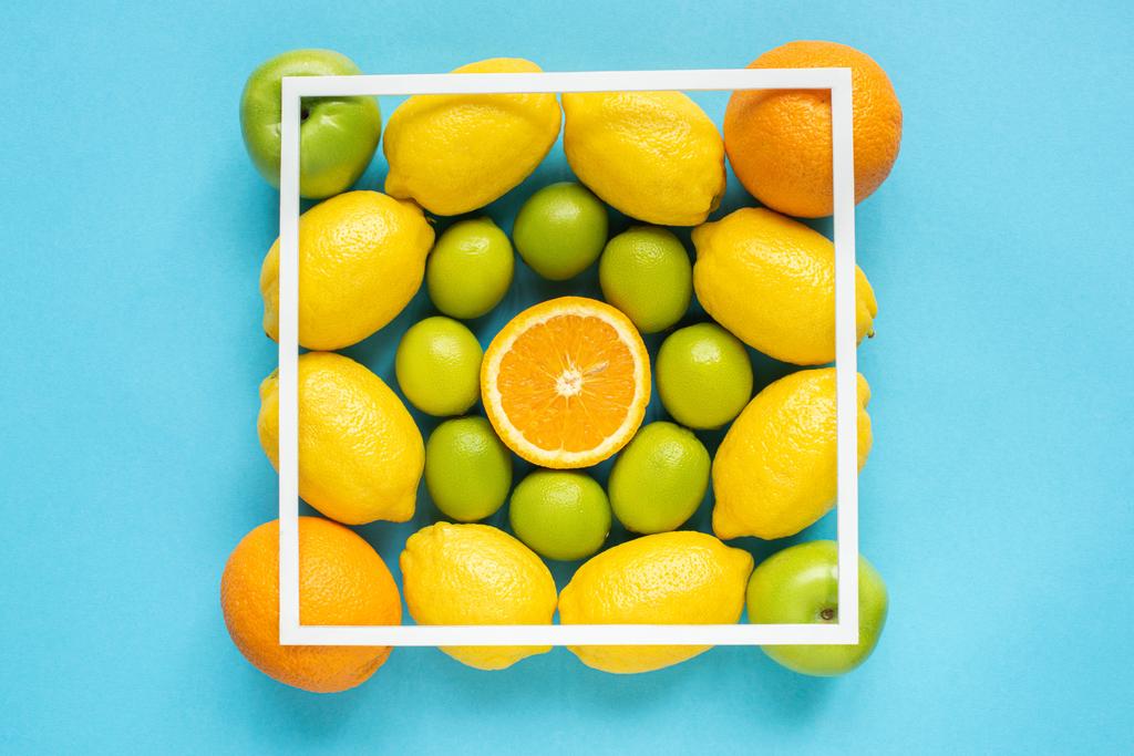 vista superior de frutas frescas y marco cuadrado sobre fondo azul
 - Foto, imagen