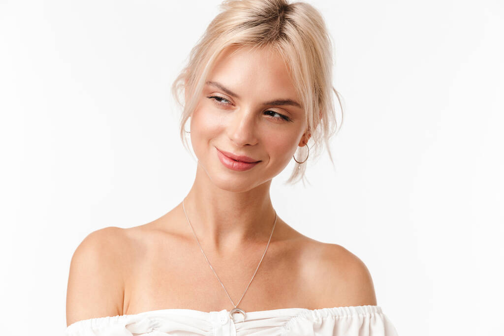 Imagem de mulher loira feliz em brincos sorrindo e olhando para o lado isolado sobre fundo branco
 - Foto, Imagem