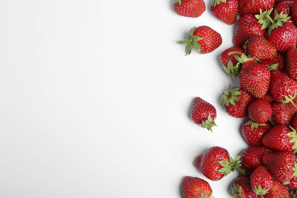 Lekkere rijpe aardbeien op witte achtergrond, vlak gelegd. Ruimte voor tekst - Foto, afbeelding
