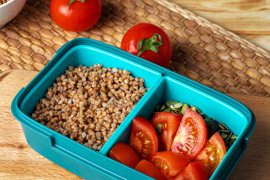 Blue lunch box with buckwheat and tomatoes - Photo, Image