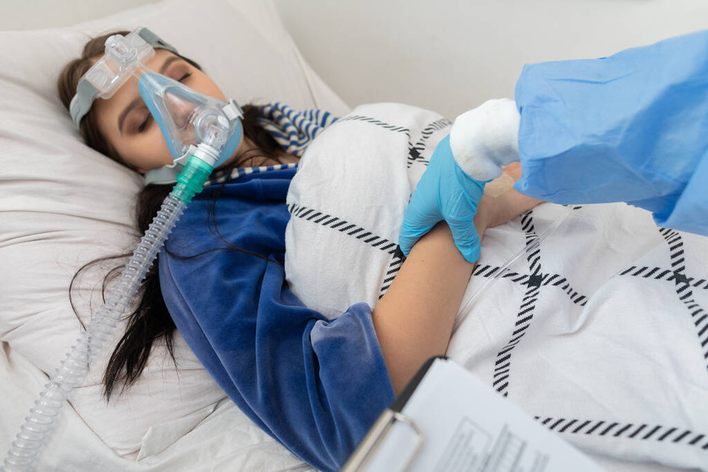 Kan nabzını kontrol ediyor. Bulaşıcı koğuş hekimi. Genç bir kız hastane yatağında yatıyor.. - Fotoğraf, Görsel
