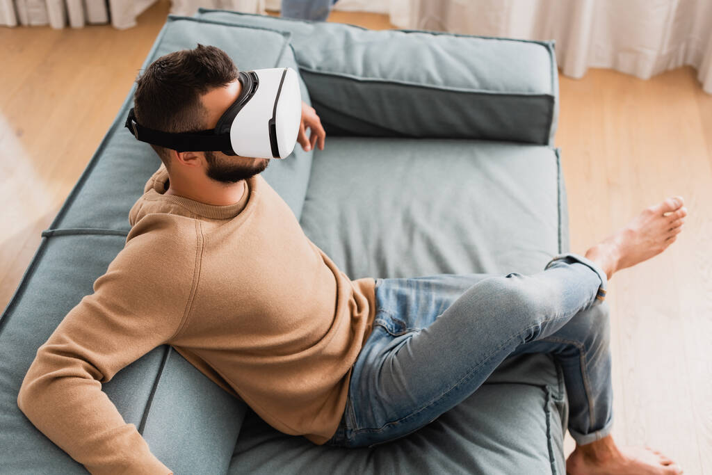 nad głową widok brodatego człowieka w wirtualnej rzeczywistości zestaw słuchawkowy w salonie  - Zdjęcie, obraz