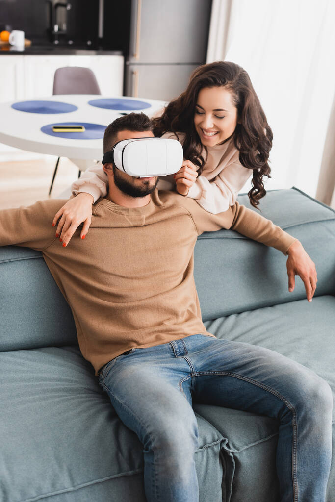 menina alegre olhando para namorado barbudo em fone de ouvido realidade virtual
  - Foto, Imagem