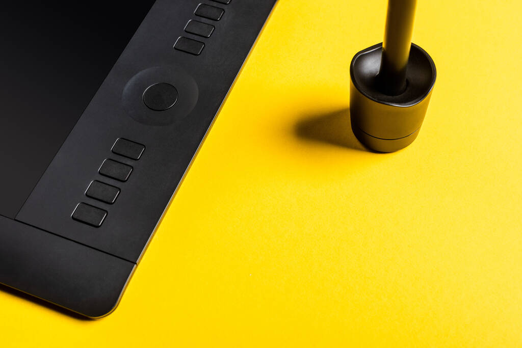 Close-up weergave van stylus in standaard en grafische tablet op gele achtergrond - Foto, afbeelding