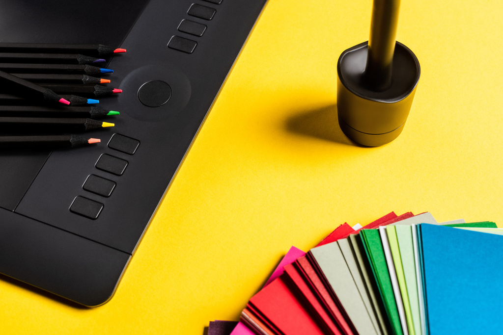 Sarı yüzeydeki renk örneklerini, grafik tabletlerini ve renk kalemlerini kapat - Fotoğraf, Görsel