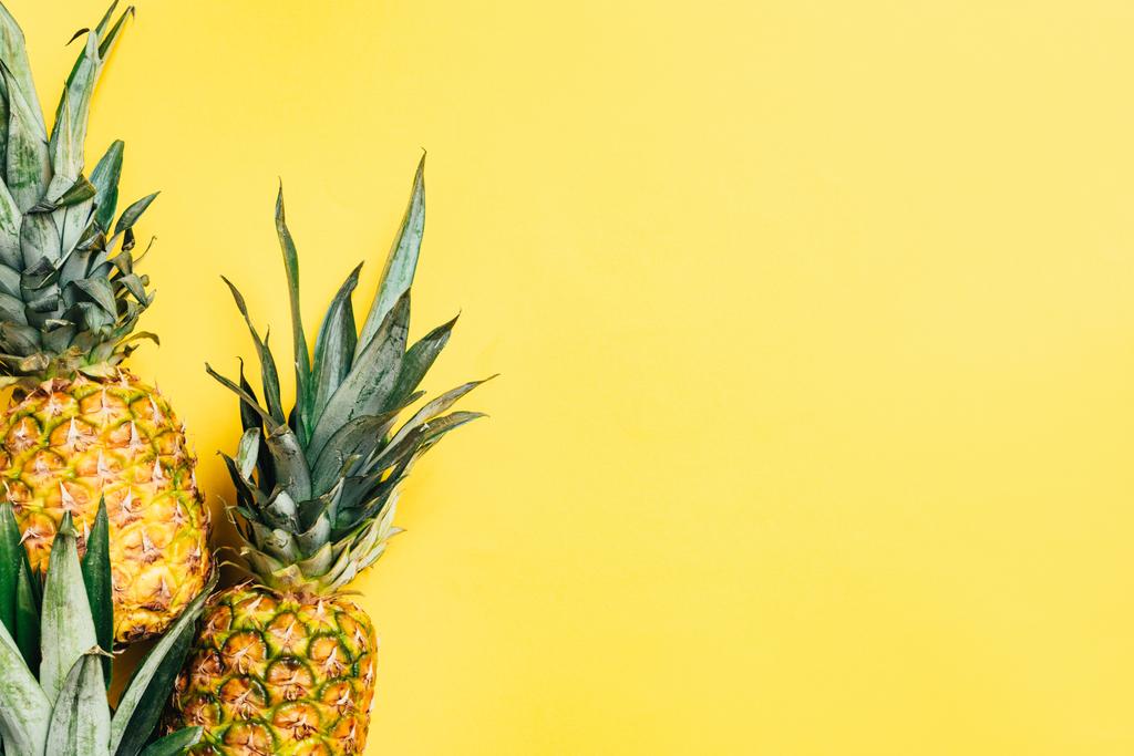 top view of fresh tasty pineapples on yellow background - Photo, Image