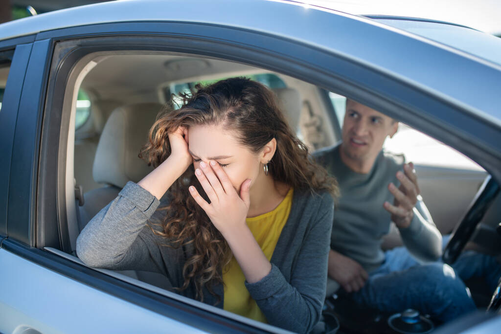 Femme en pleurs et homme en colère assis dans une voiture - Photo, image