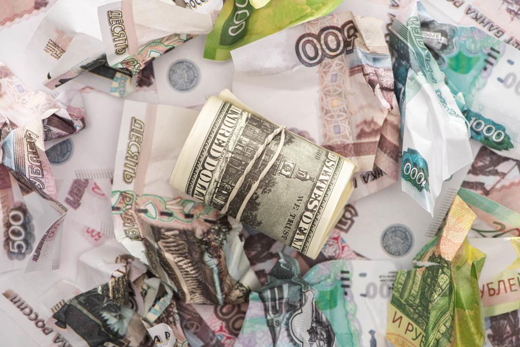 top pohled na cash roll s dolary v blízkosti zmačkaných rublových bankovek  - Fotografie, Obrázek