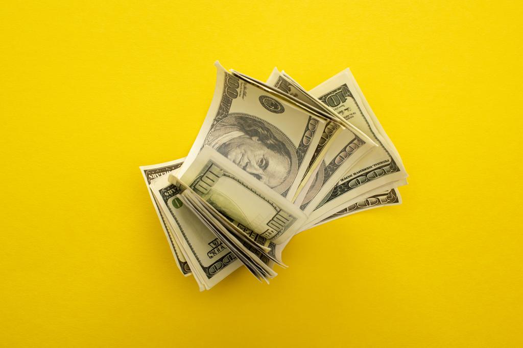 вид зверху на доларові банкноти ізольовані на жовтому
  - Фото, зображення