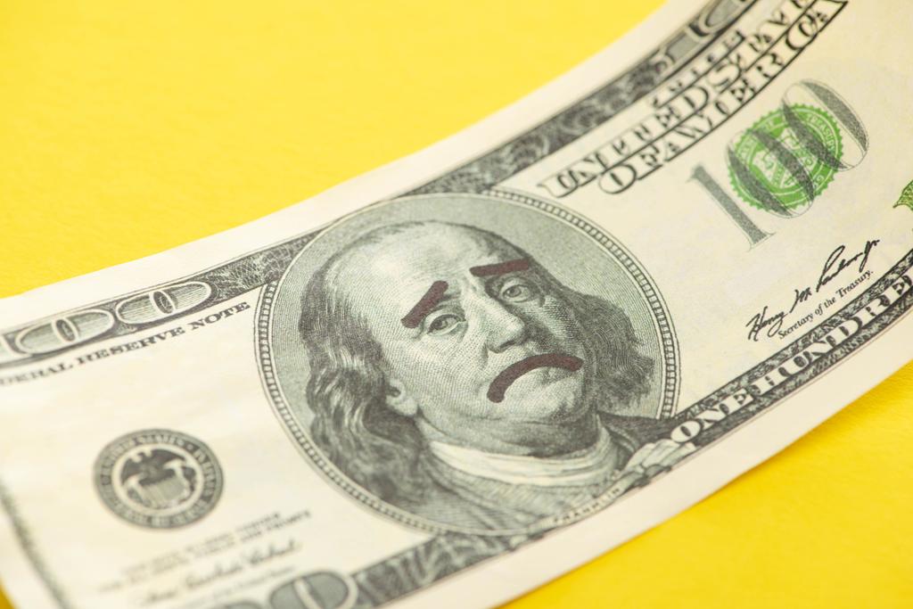 close up of dollar banknote with sad face drawing isolated on yellow  - Photo, Image