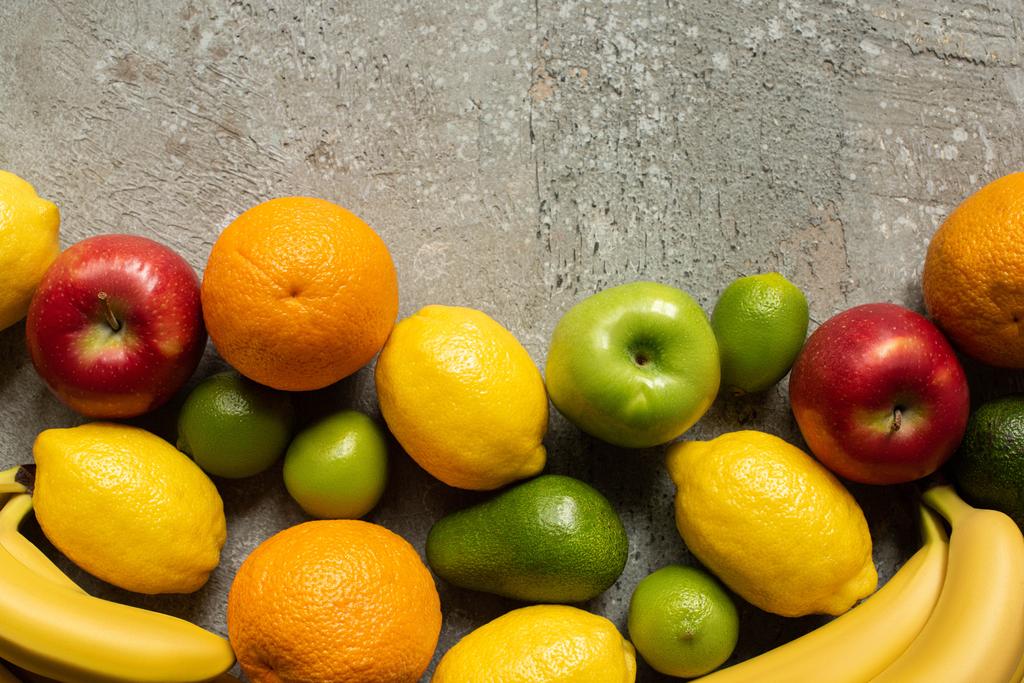 вид сверху на вкусные разноцветные фрукты на серой бетонной поверхности
 - Фото, изображение