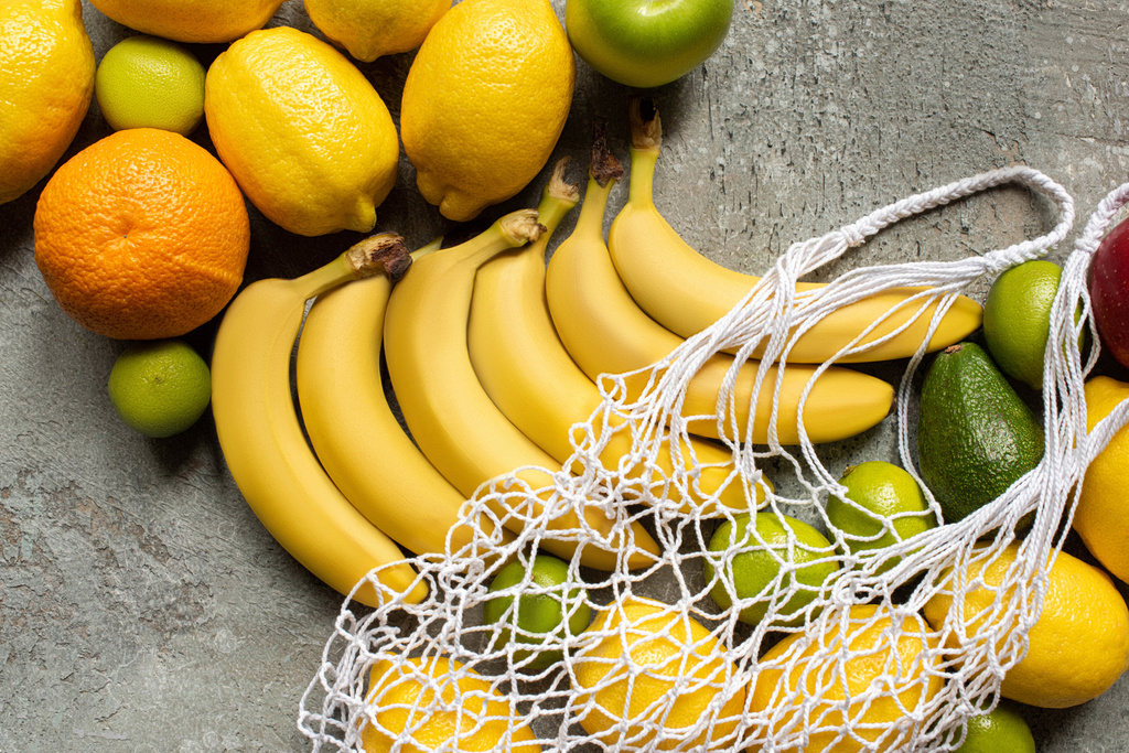 vue de dessus des fruits délicieux colorés et sac à ficelle sur la surface en béton gris
 - Photo, image