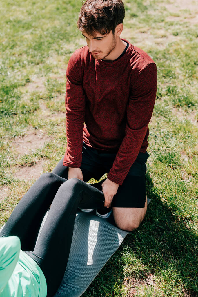 Vysoký úhel pohledu sportovce podporující sportovkyni při tréninku v parku  - Fotografie, Obrázek