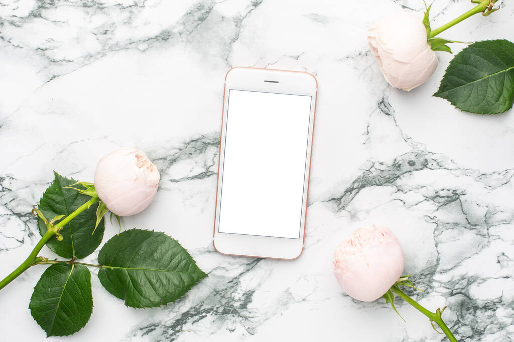 Λευκά τριαντάφυλλα με κινητό τηλέφωνο σε λευκό και μαύρο μάρμαρο φόντο με copyspace top view - Φωτογραφία, εικόνα