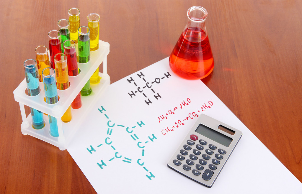 Тестові трубки з барвистими рідинами та формулами на столі
 - Фото, зображення