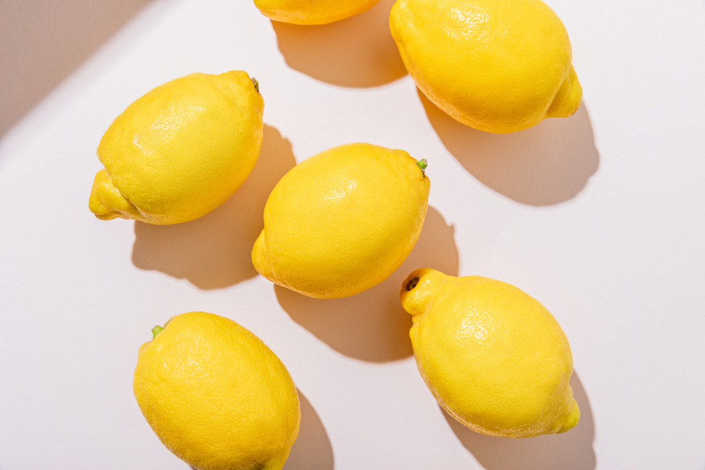 影のある灰色のテーブルの上から見た新鮮なレモン - 写真・画像