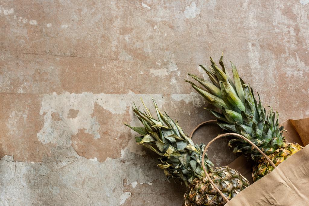 top view of ripe pineapples in paper bag on weathered surface - Photo, Image