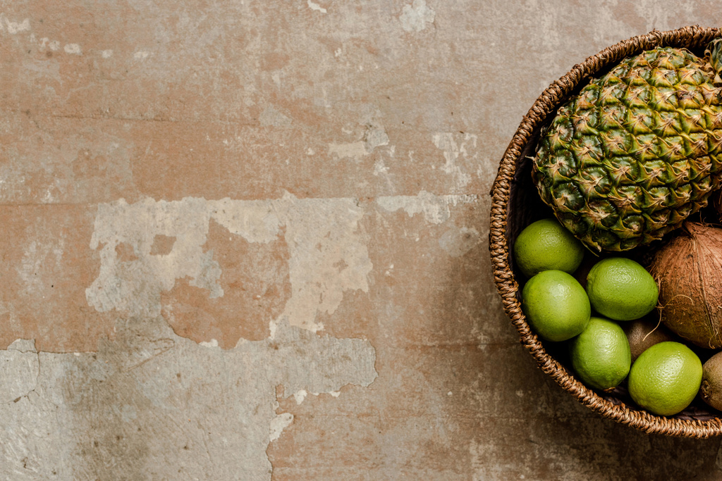 vista superior de frutas exóticas maduras em cesta de vime na superfície resistida
 - Foto, Imagem