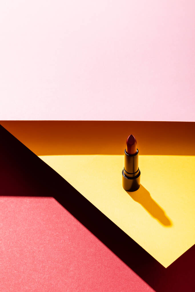shadow near lipstick on yellow, crimson and pink  - Photo, Image