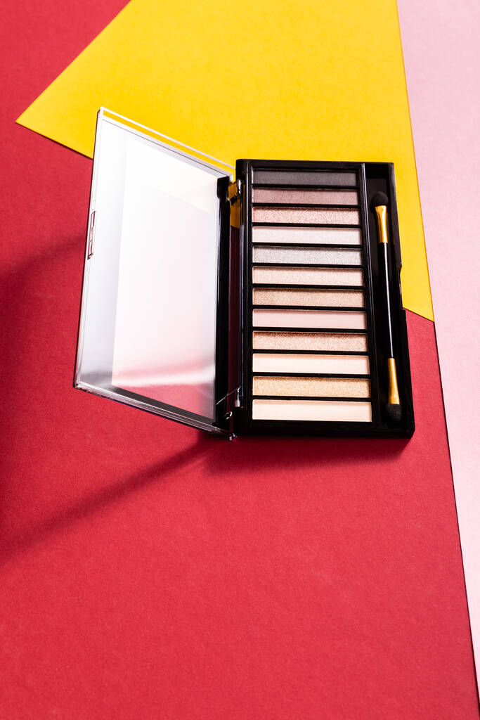 paleta de sombra de olhos e aplicador de sombra dupla face em vermelho, rosa e amarelo
 - Foto, Imagem