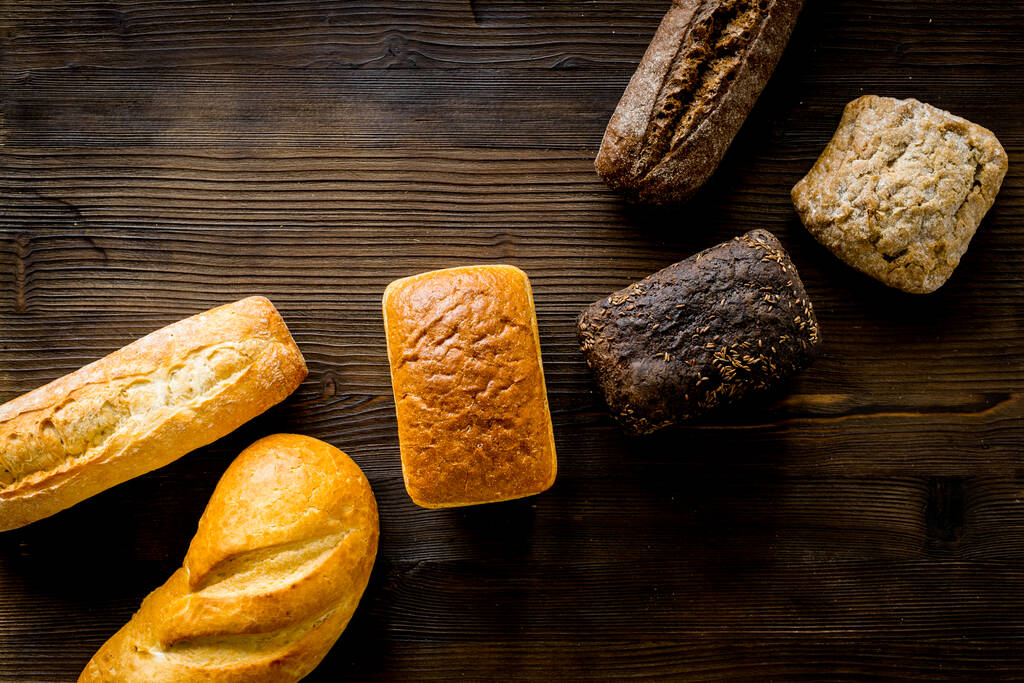 Комплект хлеба с пшеничным ухом на деревянном столе. Вид сверху
 - Фото, изображение