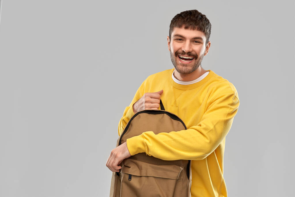 szczęśliwy uśmiechnięty młody człowiek z plecakiem - Zdjęcie, obraz