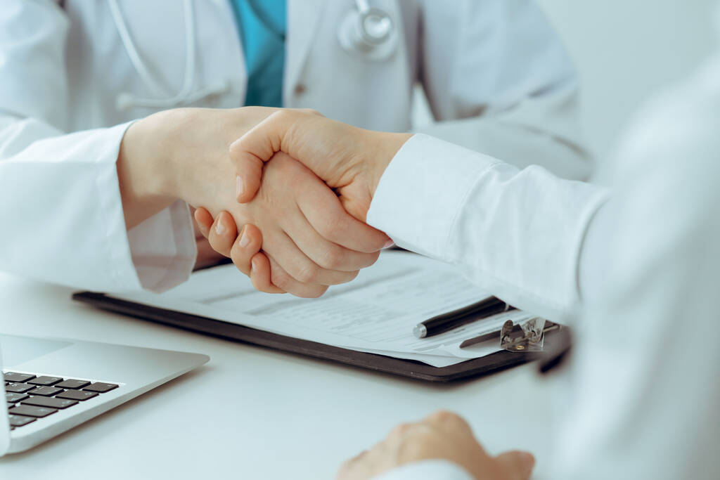 Docteur et patient serrant la main, gros plan. Concept de médecine, de santé et de confiance - Photo, image