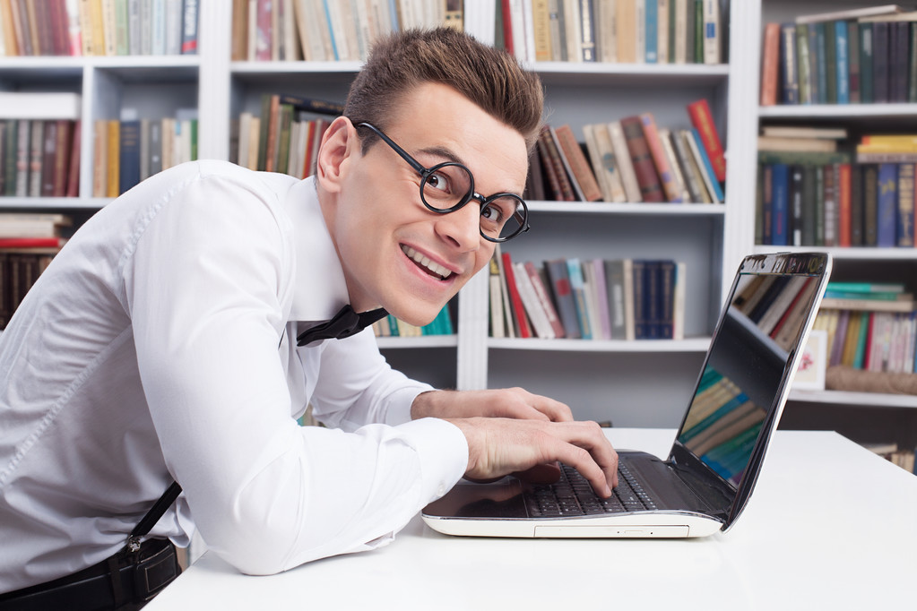 Hombre nerd en camisa y pajarita escribiendo algo en la computadora
 - Foto, Imagen