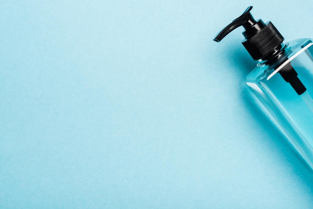 πάνω όψη του hand sanitizer σε διάφανο μπουκάλι με dispencer σε μπλε - Φωτογραφία, εικόνα