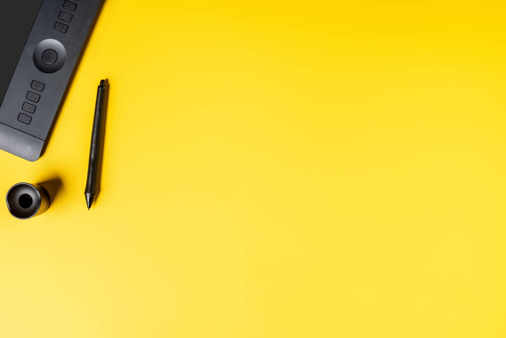 вид зверху на тримач стилуса і малюнок планшета біля стилуса на жовтому
 - Фото, зображення