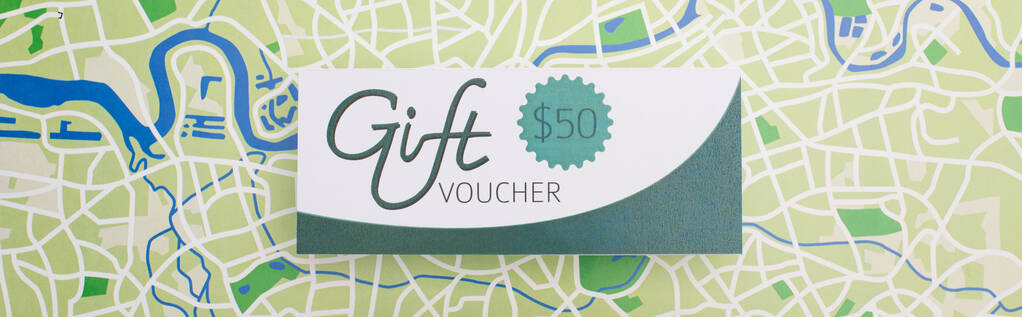Panoramic crop of gift voucher with 50 dollars sign on map surface - Photo, Image