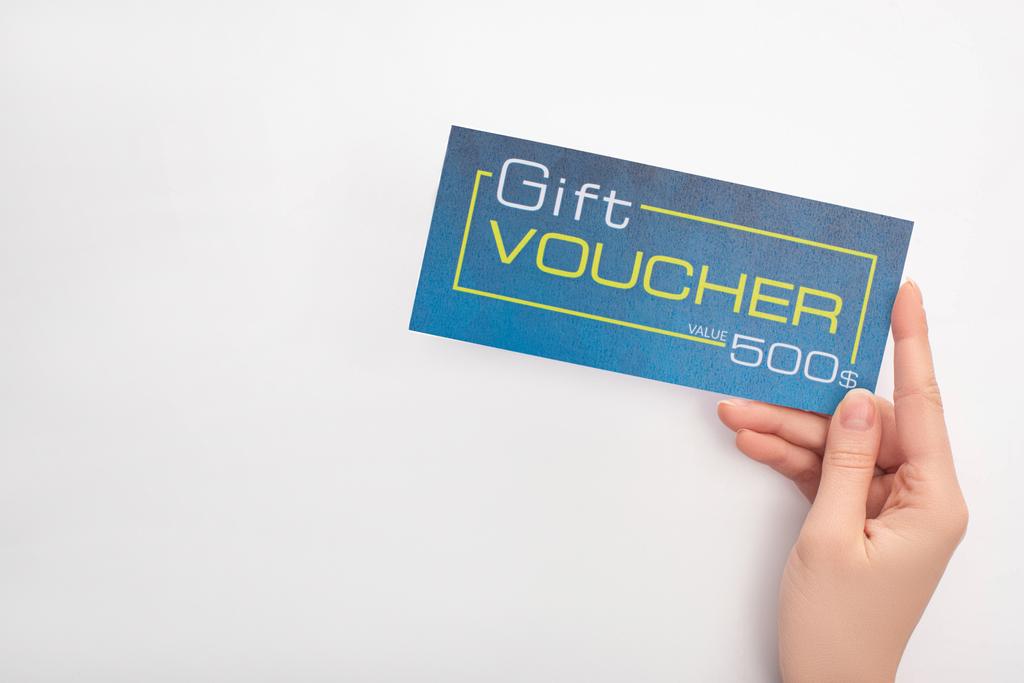 Top view of woman holding blue gift voucher with value and dollar sign on white background - Photo, Image