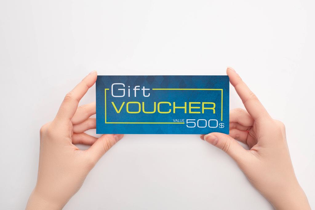 Top view of woman holding gift voucher with dollar sign on white background - Photo, Image
