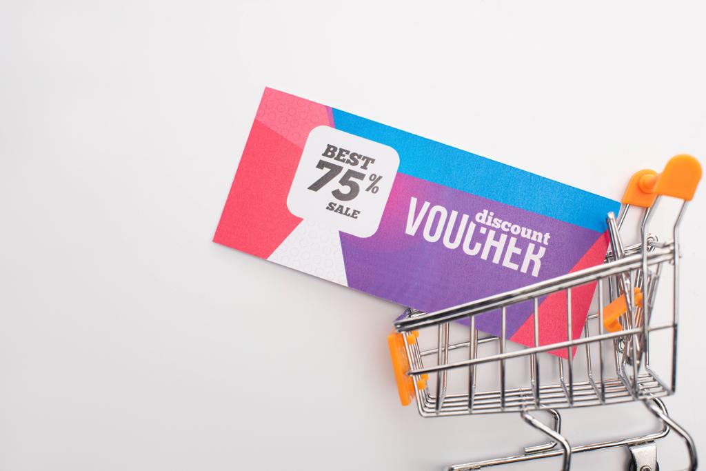 Top view of discount voucher in toy shopping cart on white background - Photo, Image