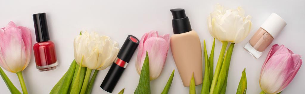 Cultivo panorámico de cosméticos decorativos y tulipanes sobre fondo blanco
 - Foto, imagen