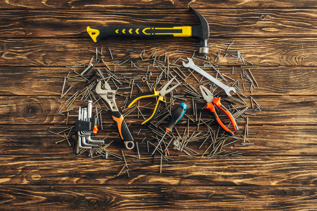 верхний вид инструментов и металлических ногтей на деревянной поверхности, концепция трудового дня
  - Фото, изображение
