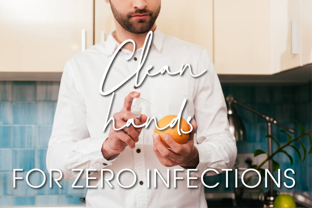 Vista cortada do homem desinfetando laranja com desinfetante de mão na cozinha, mãos limpas para ilustração de infecção zero
 - Foto, Imagem