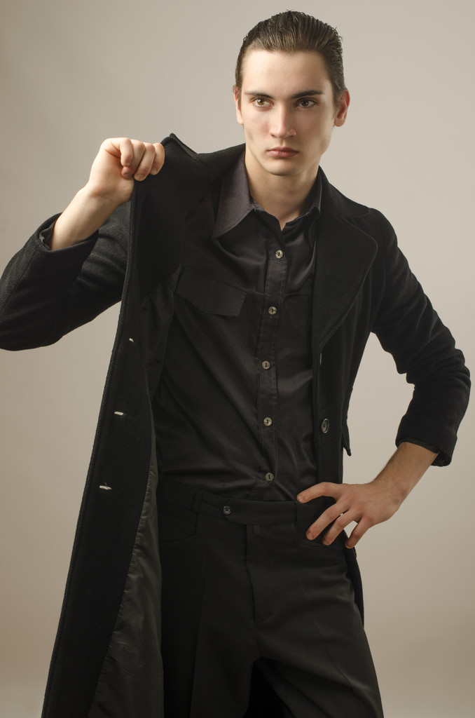 黒の t シャツ、ズボン、長いコートを着ているに身を包んだ若いビジネスマン - 写真・画像