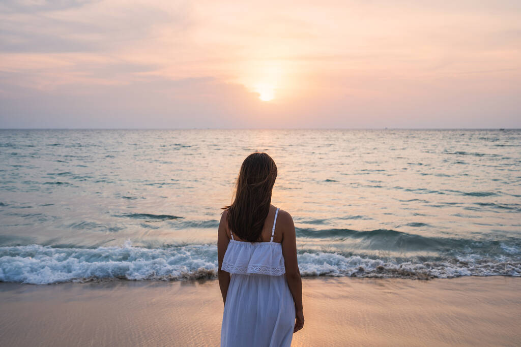 Μοναχική νεαρή Ασιάτισσα που στέκεται στην παραλία το ηλιοβασίλεμα - Φωτογραφία, εικόνα