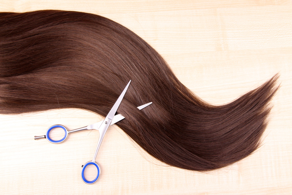 Довге коричневе волосся і ножиці на дерев'яному фоні
 - Фото, зображення