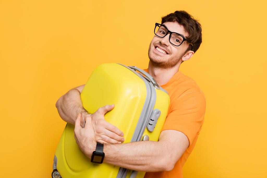 szczęśliwy mężczyzna turysta gospodarstwa walizka na letnie wakacje odizolowane na żółto  - Zdjęcie, obraz