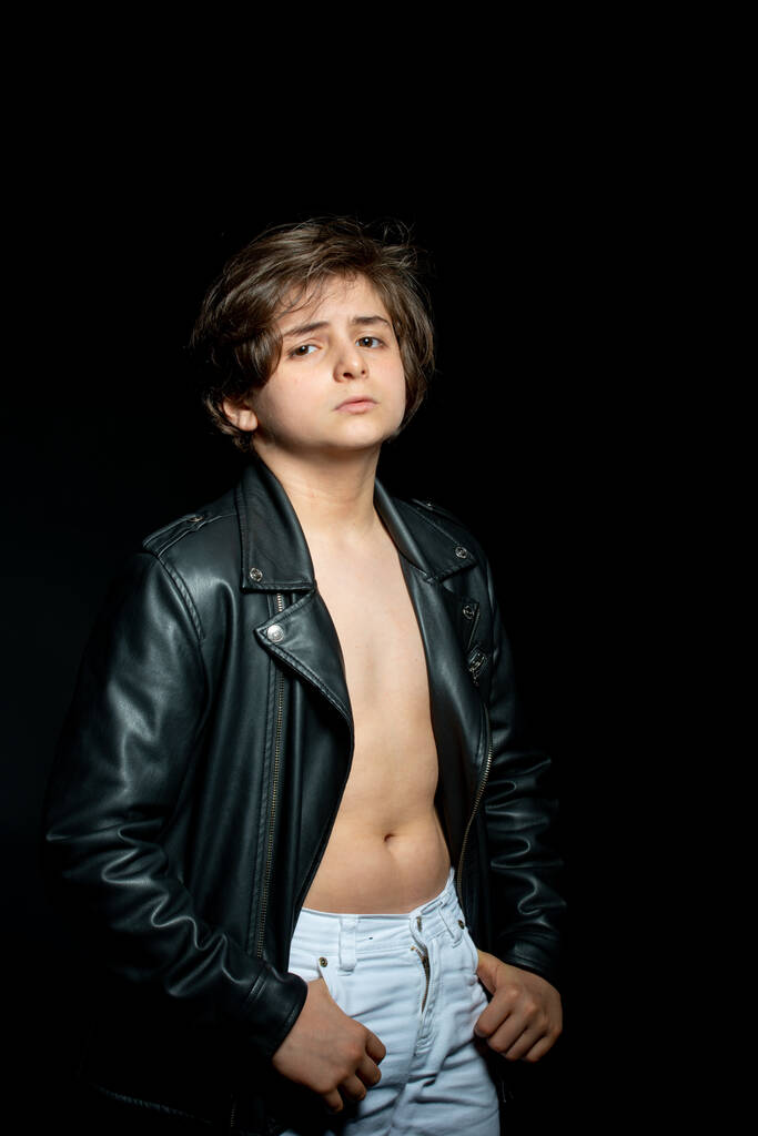 preteen menino em jaqueta de couro preto posando no fundo preto
 - Foto, Imagem