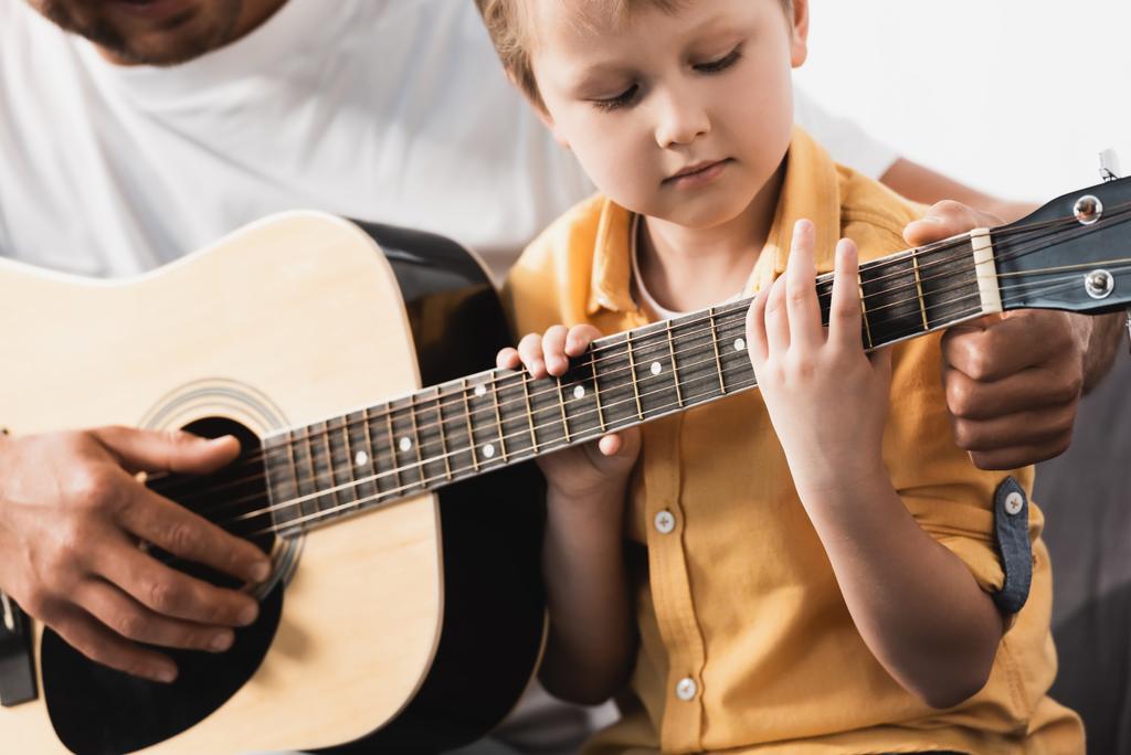 Baba 'nın özenli oğluna akustik gitar çalmayı öğrettiği görüntüler. - Fotoğraf, Görsel