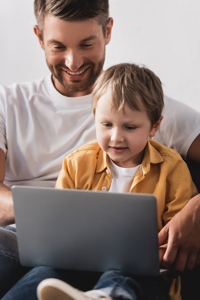 foco seletivo de pai e filho usando laptop juntos em casa
 - Foto, Imagem